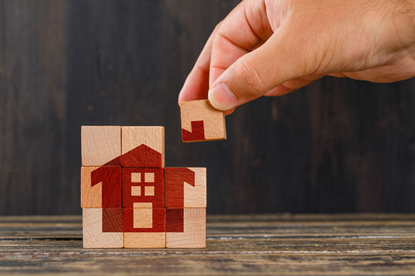 stay home concept wooden table side view hand holding wooden cube